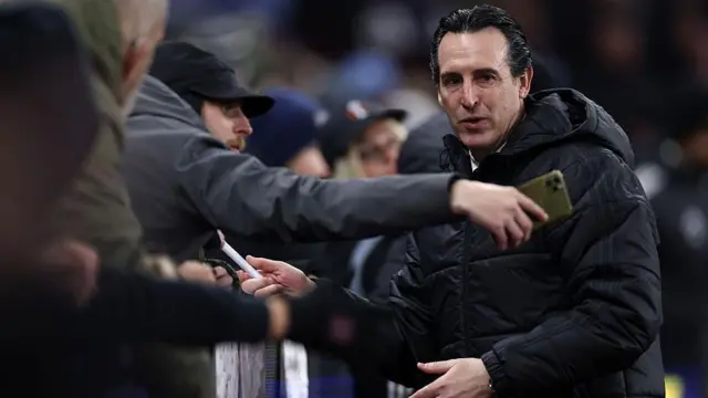 Unai Emery shakes hands with fans and one takes a selfie of them