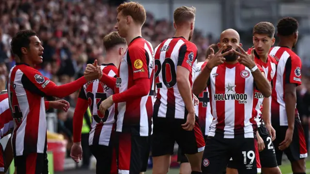 Brentford's French-born Cameroonian striker #19 Bryan Mbeumo (3R) celebrates scoring the opening goal during the English Premier League football match between Brentford and West Ham United at the Gtech Community Stadium