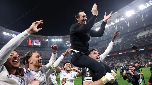 Unai Emery, manager of Aston Villa, celebrates on the shoulders of Emiliano Martinez
