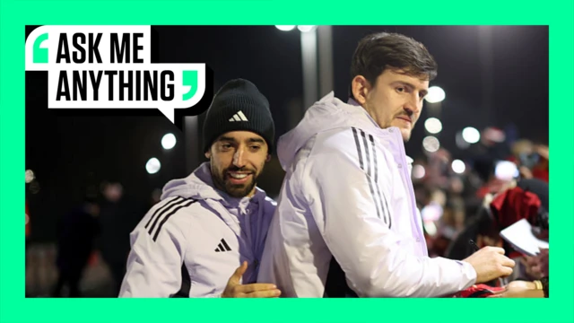 Bruno Fernandes and Harry Maguire signing autographs on the green 'Ask Me Anything' border