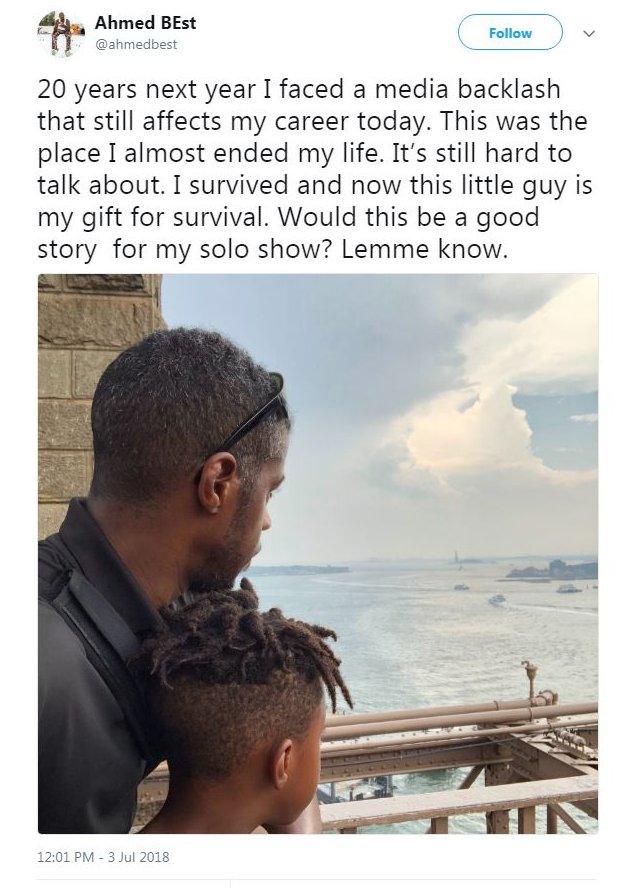 A picture of Ahmed Best with his young son facing away from the camera, and a tweet reading: "20 years next year I faced a media backlash that still affects my career today. This was the place I almost ended my life. It's still hard to talk about. I survived and now this little guy is my gift for survival. Would this be a good story for my solo show? Lemme know."