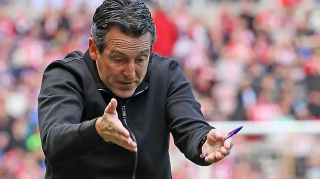 Unai Emery signals to his players in frustration. He looks angry.