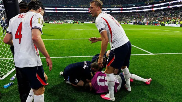 Dan Burn and Declan Rice look concerned as Jordan Henderson receives treatment while lying on the side of the pitch