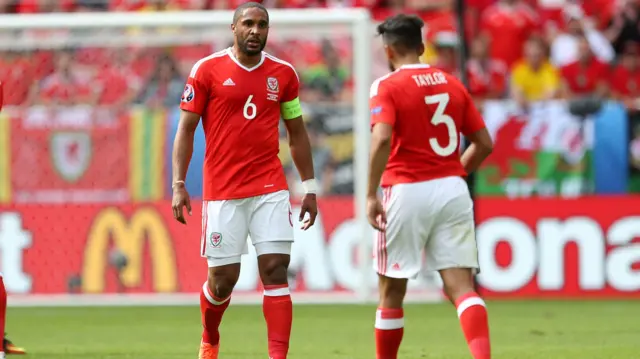 Neil Taylor walks towards Wales team-mate Ashley Williams at Euro 2016