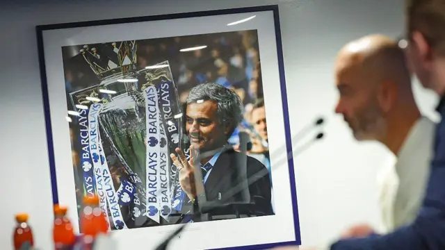 Picture of Jose Mourinho holding trophies on the wall at Chelsea's Drake Suite.