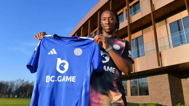 Woyo Coulibaly holding a Leicester shirt