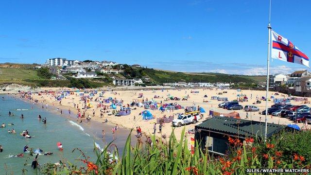 Beachgoers line the beach on a clear day