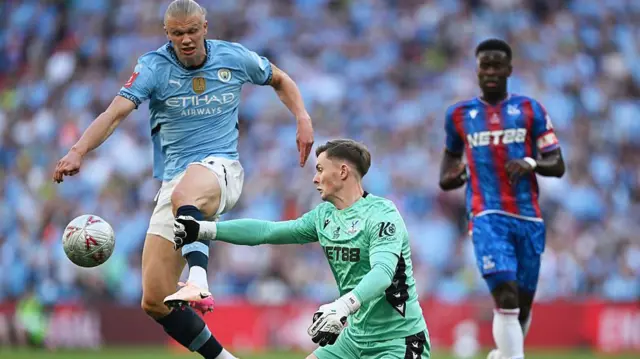 Erling Haaland and Dean Henderson challenge for the ball