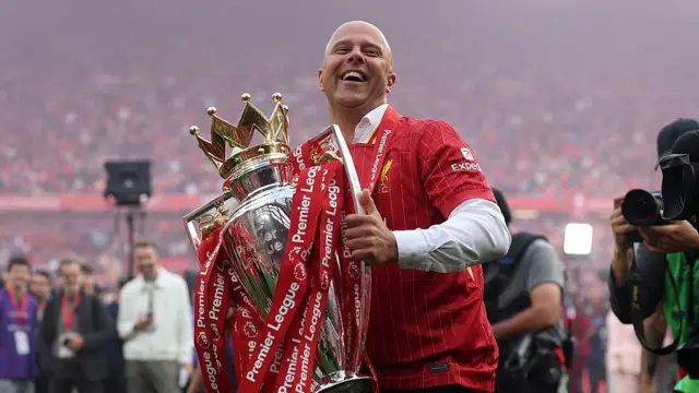 Arne Slot celebrates with the Premier League trophy