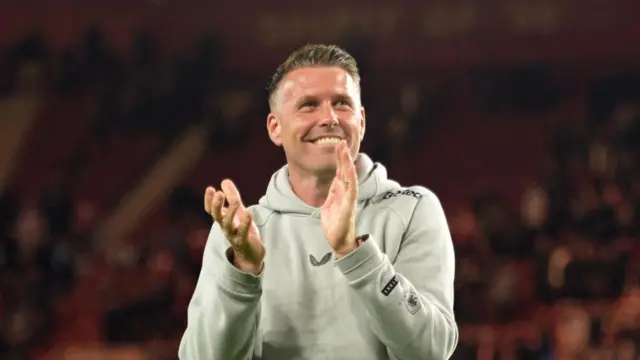 Rob Edwards, with a beaming smile, claps the Middlesbrough fans after their win over West Brom