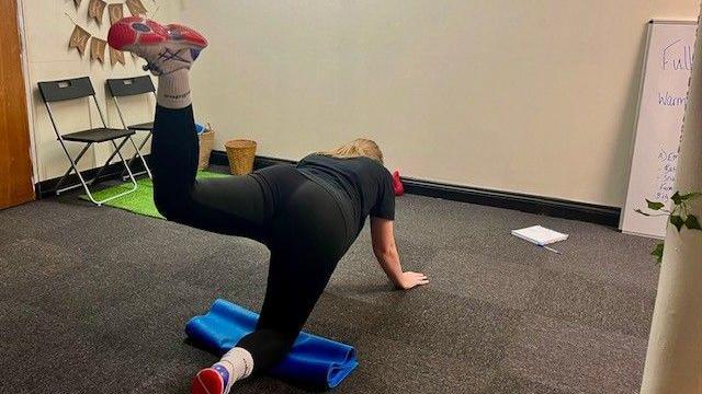 Back of a woman doing a stretching exercise.