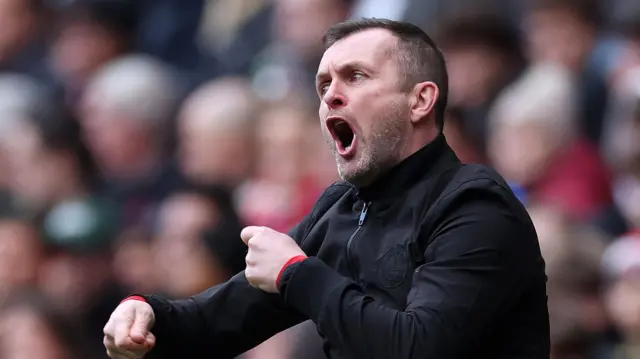 Nathan Jones shouting instructions to his players with his fists clenched in a gesture about tactics