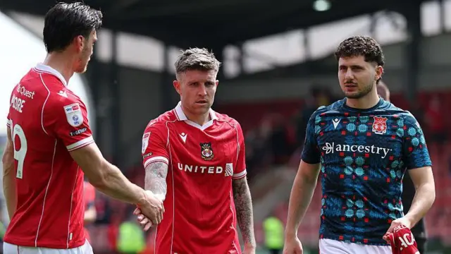 Liberato Cacace (right) watches team-mates Kieffer Moore (left) and Josh Windass (centre) shake hands after a game