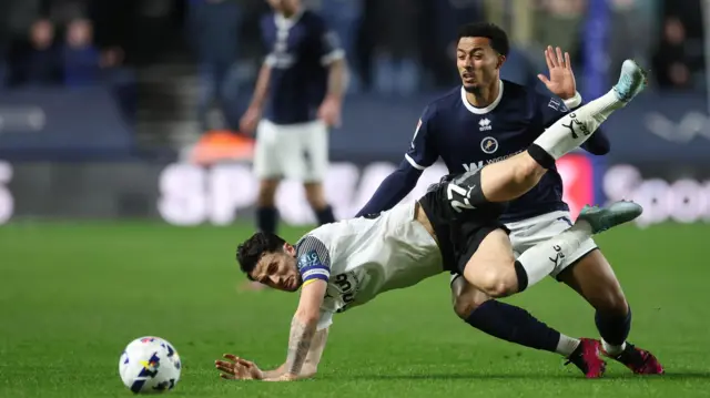 Lewis Travis of Derby County talls to the ground as he challenges Millwall's Femi Azeez for the ball
