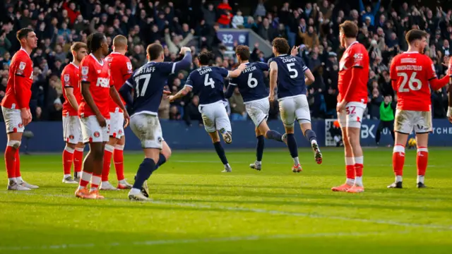 Charlton players look dejected as Millwall celebrate scoring in a 4-0 win for the Lions