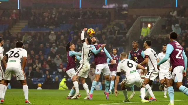 Swansea's Matt Grimes handles the ball as Jay Rodriguez of Burnley heads in a crowded penalty area at Turf Moor