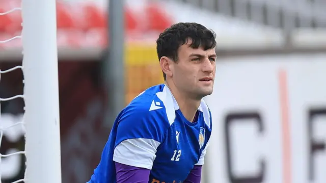 Tom Smith in a blue goalkeeper's shirt