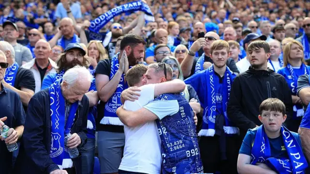 Everton fans hug in the crowd at the end of the match against Southampton 