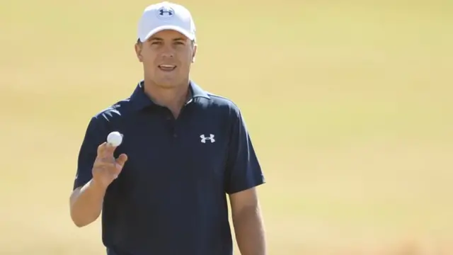 Jordan Spieth holds up his ball after a putt