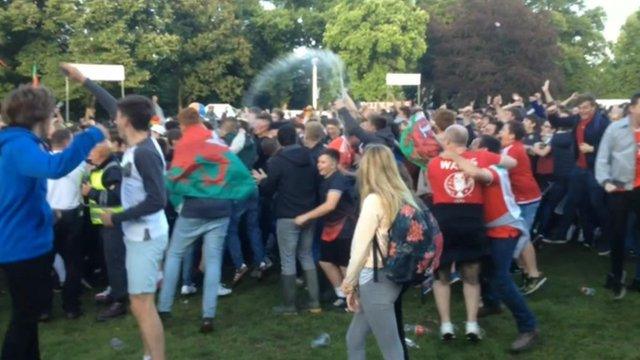 Supporters at the fanzone in Cardiff throw drinks and wave flags in celebration at Wales' second goal in 20 minutes