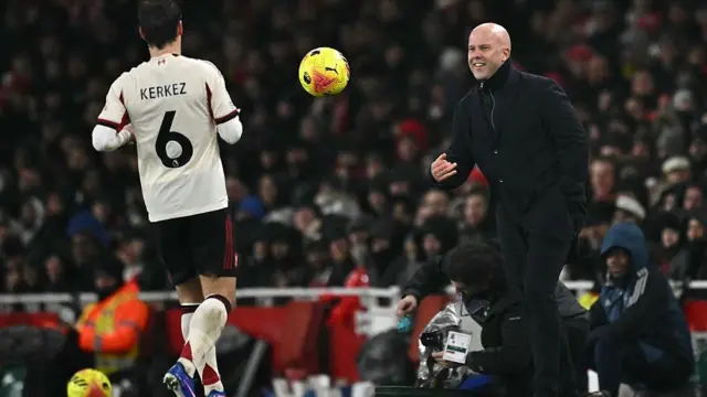 Arne Slot throws the ball to Milos Kerkez