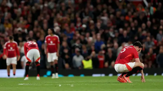 Harry Maguire on haunches looking dejected