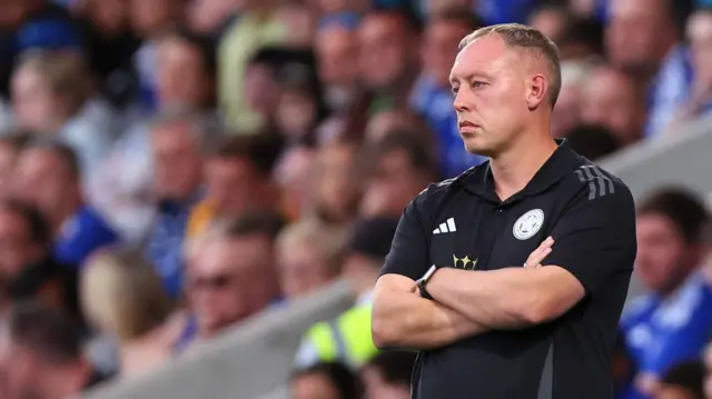 Steve Cooper stands with his arms crossed while watching his Leicester side. 