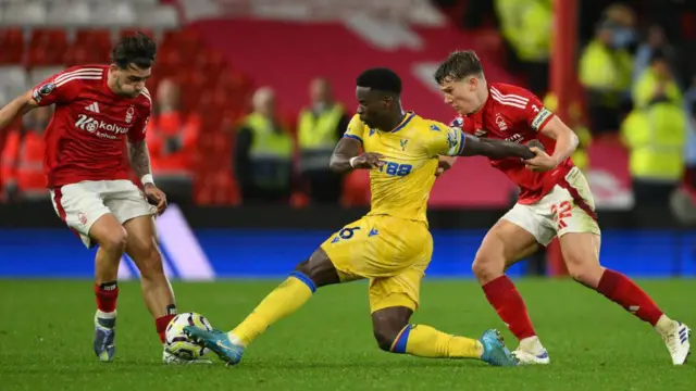 Marc Guehi of Crystal Palace battles with Jota Silva of Nottingham Forest under pressure from Ryan Yates of Nottingham Forest during the Premier League match between Nottingham Forest and Crystal Palace at the City Ground