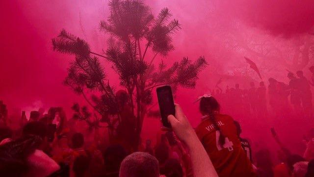 People stand amidst red flare smoke