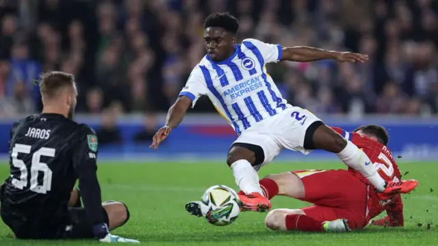 Tariq Lamptey is tackled by Andrew Robertson