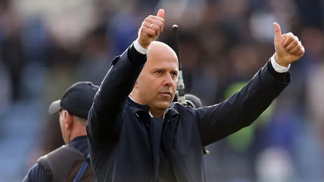 Arne Slot gestures with his thumbs up to the Liverpool fans