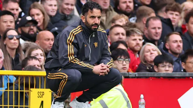 Ruben Amorim crouches and looks on from touchline during match
