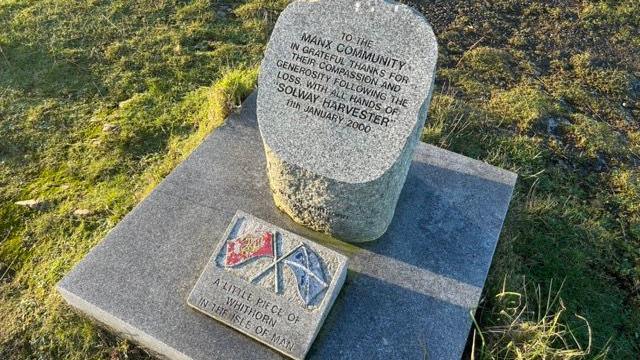 The memorial on Douglas Head. It features a harbour bollard from Whithorn with an inscription that reads "to the Manx community in grateful thanks for their compassion and generosity following the loss with all the hands of Solway Harvester 11th January 2000". It has a small square featuring the flags of Scotland and the Isle of Man in front of it featuring the words "a little piece of Whithorn in the Isle of Man".
