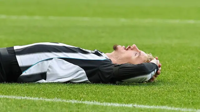 Nick Woltemade lies down on the turf