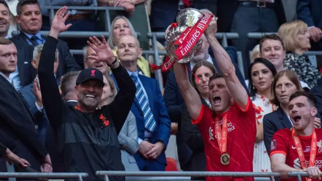 Jurgen Klopp lifts his hands as James Milner lifts the FA Cup