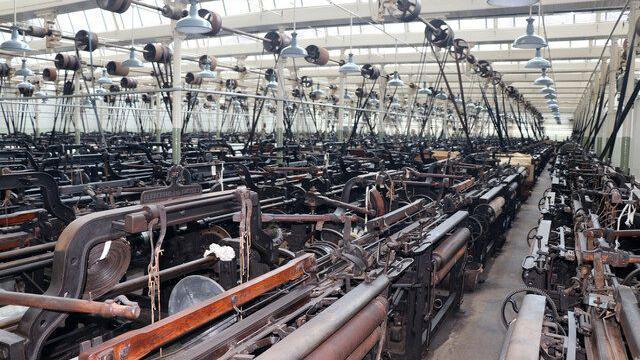 rows of Victorian industrial weaving looms on the mill floor