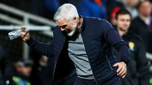 Jim Goodwin throws a water bottle