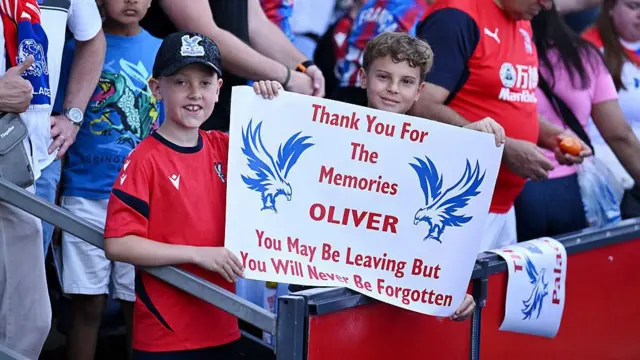 Fans of Crystal Palace hold up a sign showing support for Oliver Glasner