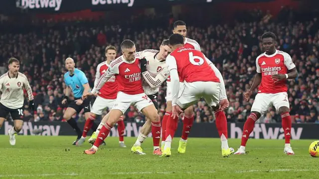 Florian Wirtz of Liverpool goes down under pressure from Leandro Trossard of Arsenal but a penalty is not given