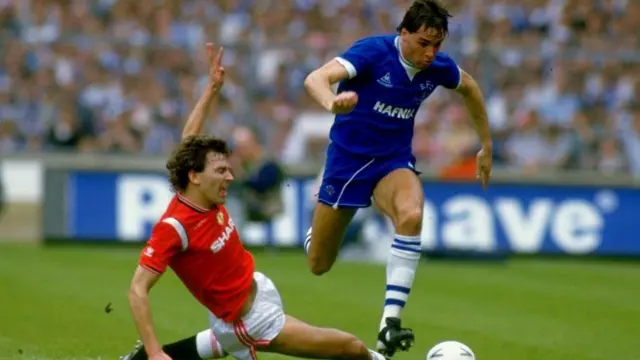 Everton's Pat van den Hauwe runs with the ball and beats Bryan Robson of Manchester United