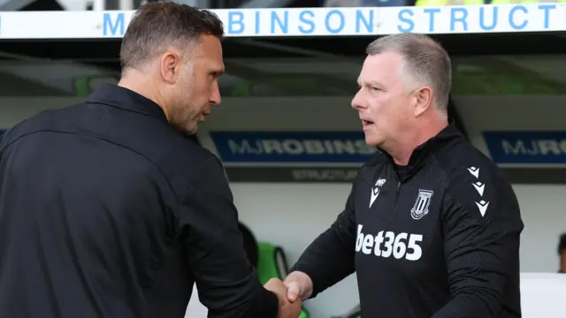 Stoke City boss Mark Robins (right) shakes the hand of Derby County head coach John Eustace