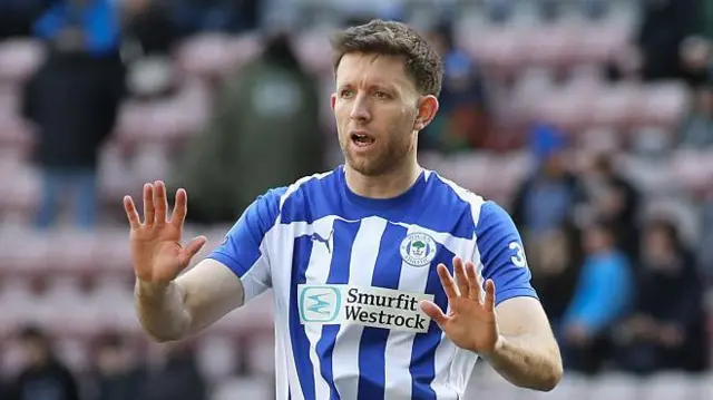 Will Aimson, wearing the blue and white shirt of Wigan, playing last season