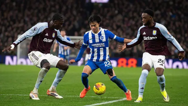 Amadou Onana and Lamare Bogarde of Aston Villa and Kaoru Mitoma of Brighton contest for the ball