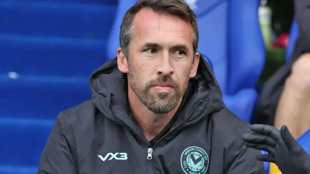 Christian Fuchs looks on from the bench during Newport's loss at Oldham