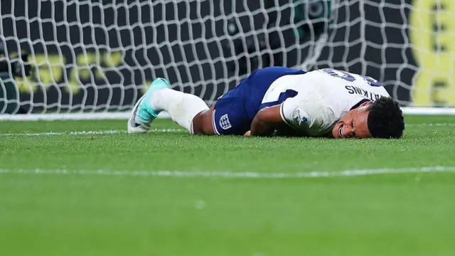 Ollie Watkins reacts as he goes down with an injury after colliding with the goalpost