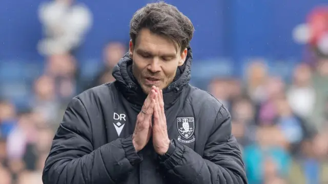 Danny Rohl with his hands together in prayer