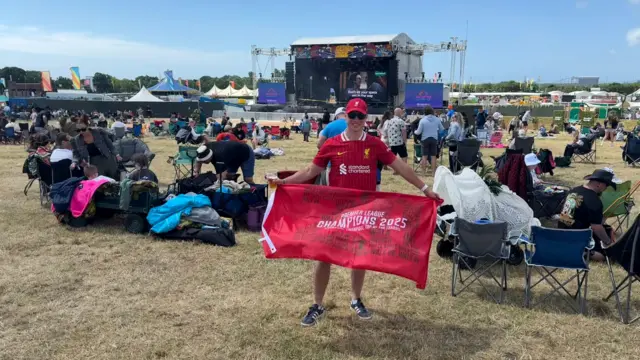 Sam holds a Liverpool flag