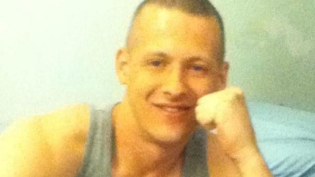 A family handout of Michael McCann. He has short dark hair, is smiling and wearing a grey vest.
