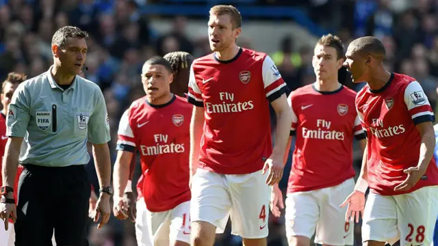 Alex Oxlade-Chamberlain (second left) stands a looks on as referee Andre Marriner (left) shows his team-mate Kieran Gibbs (right) the red card