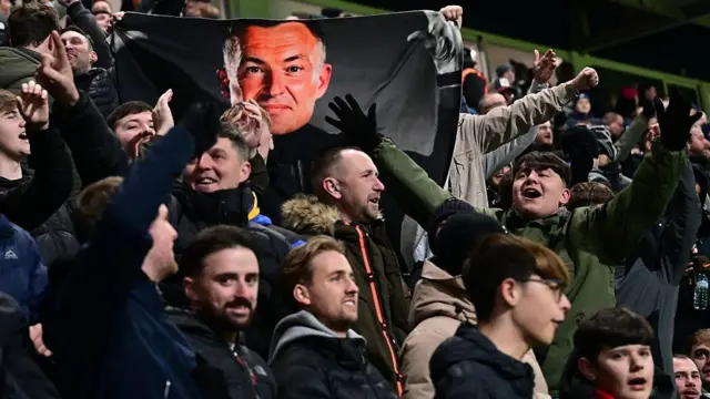 Preston fans holding a banner with the face of boss Paul Heckingbottom